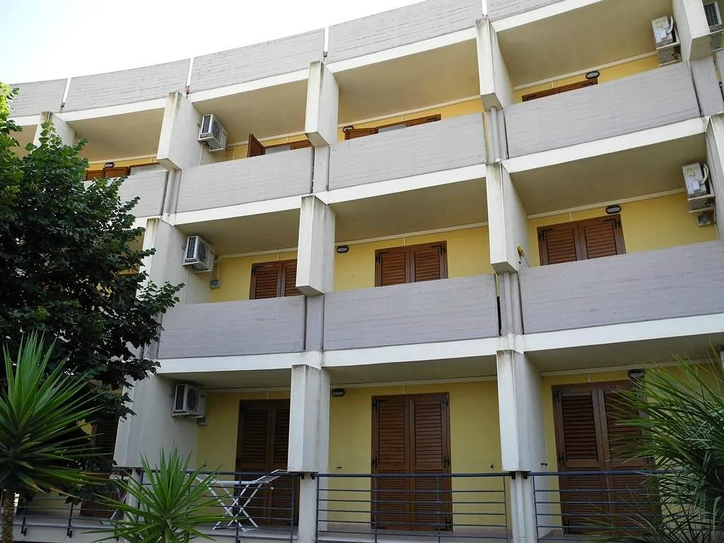 Facciata esterna dell'edificio con balconi e persiane in legno