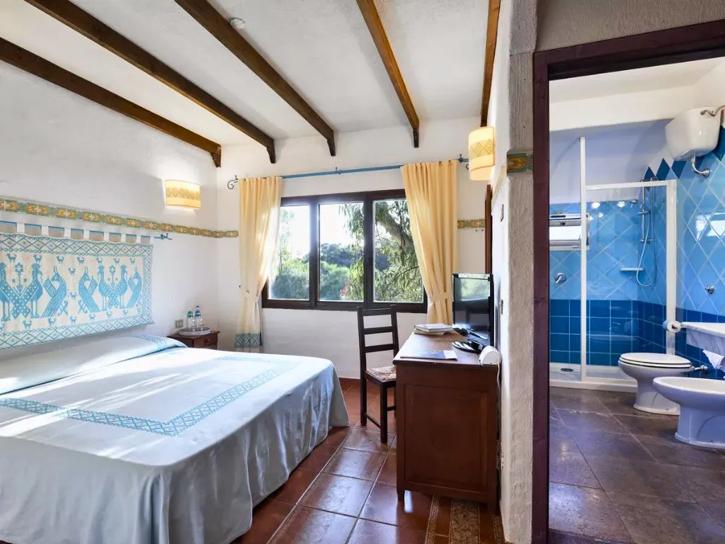 Camera con letto matrimoniale, bagno con piastrelle azzurre e decorazioni tradizionali
