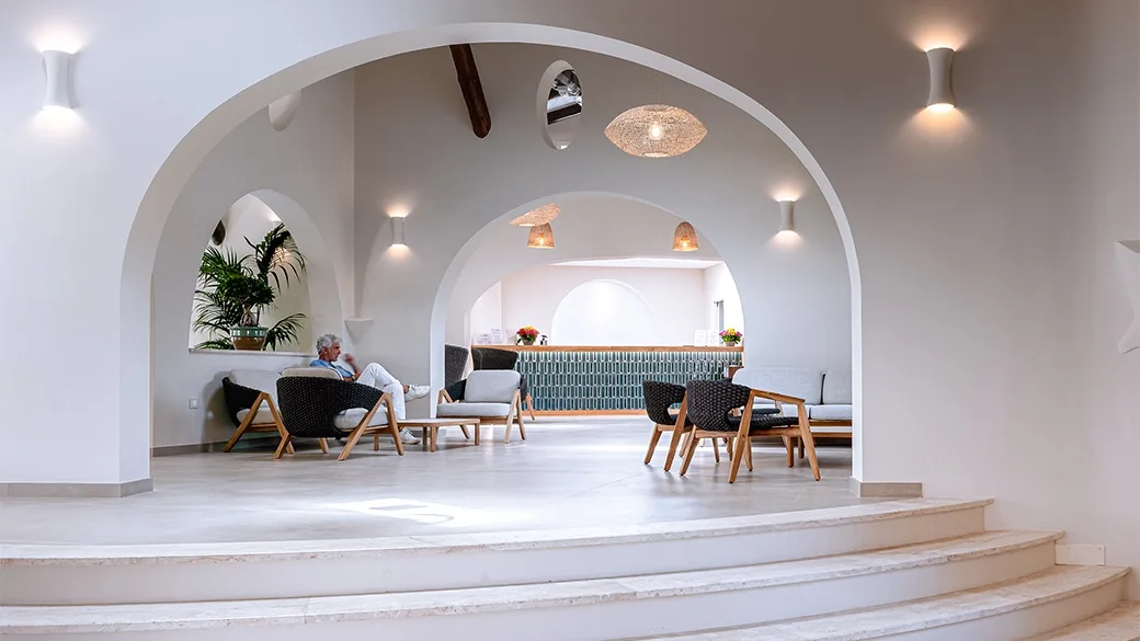 Hall dell'hotel con arredi moderni, archi bianchi e zona relax