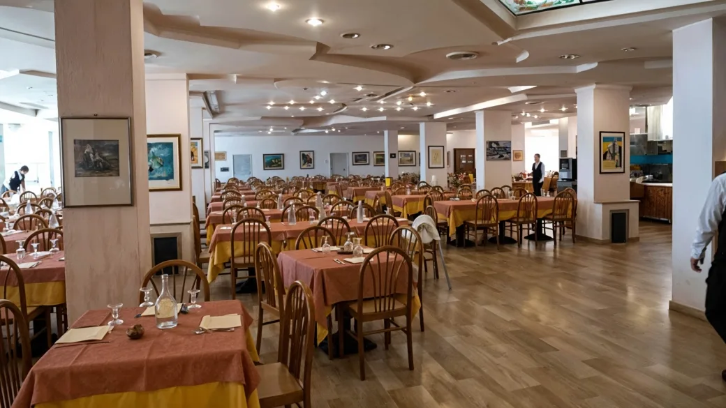 Ampia sala ristorante con tavoli apparecchiati e tovaglie colorate