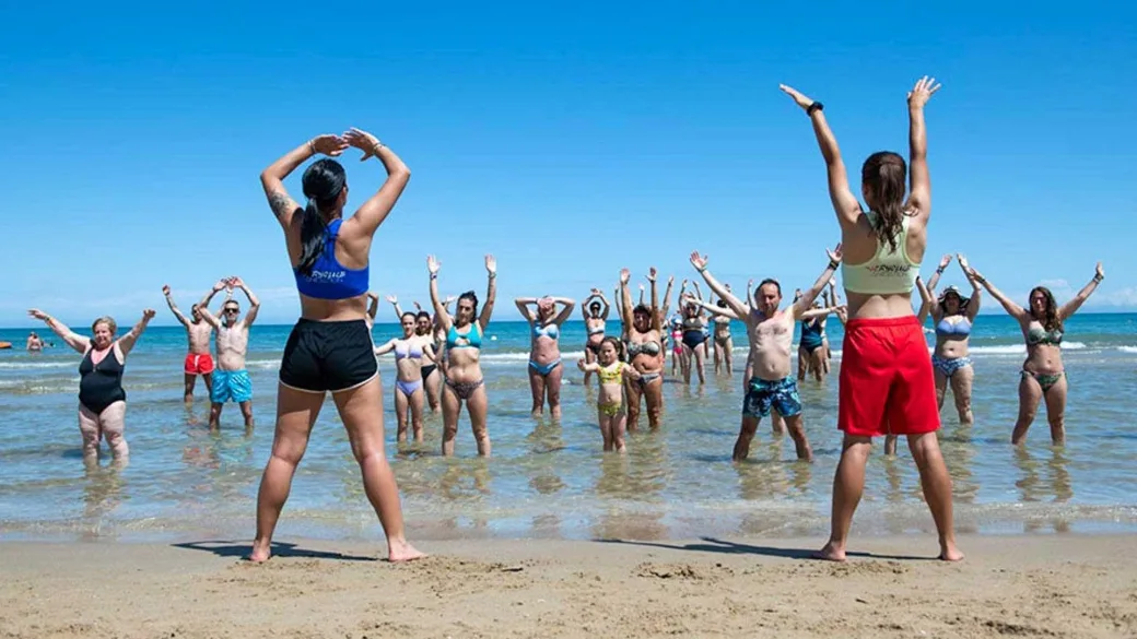 Lezione di ginnastica di gruppo in acqua sulla spiaggia