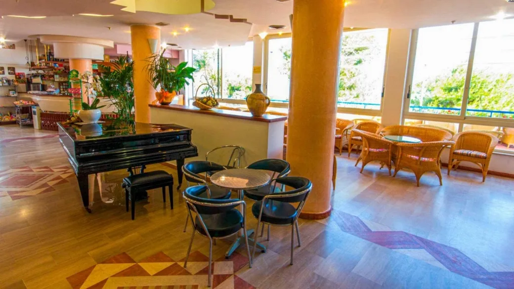Area lounge dell'hotel con pianoforte a coda e poltrone in vimini