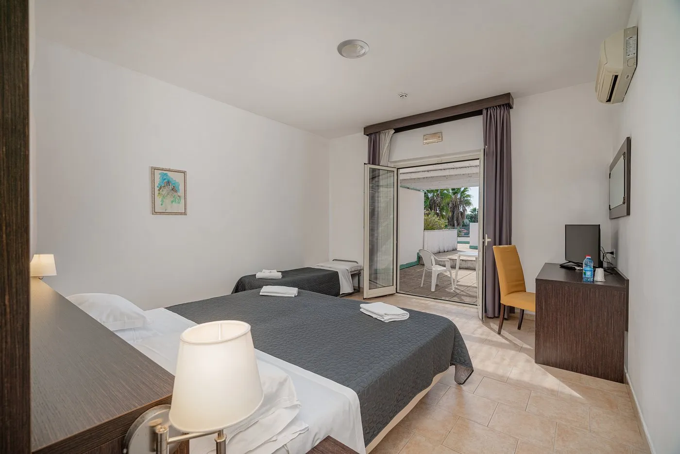 Camera con letto matrimoniale e letto singolo, aria condizionata e accesso al patio