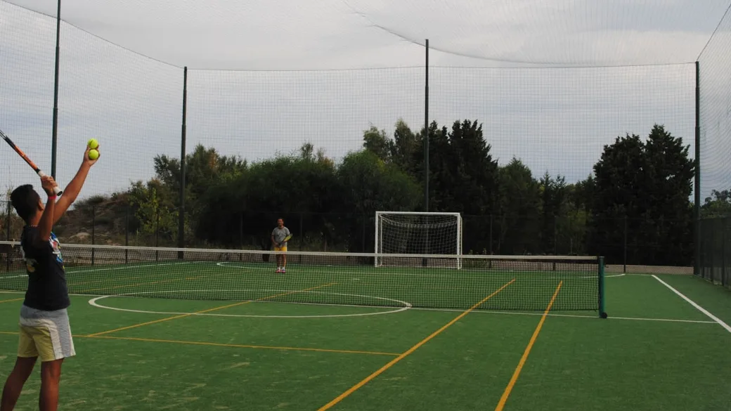Ragazzi che giocano a tennis su campo polivalente in erba sintetica