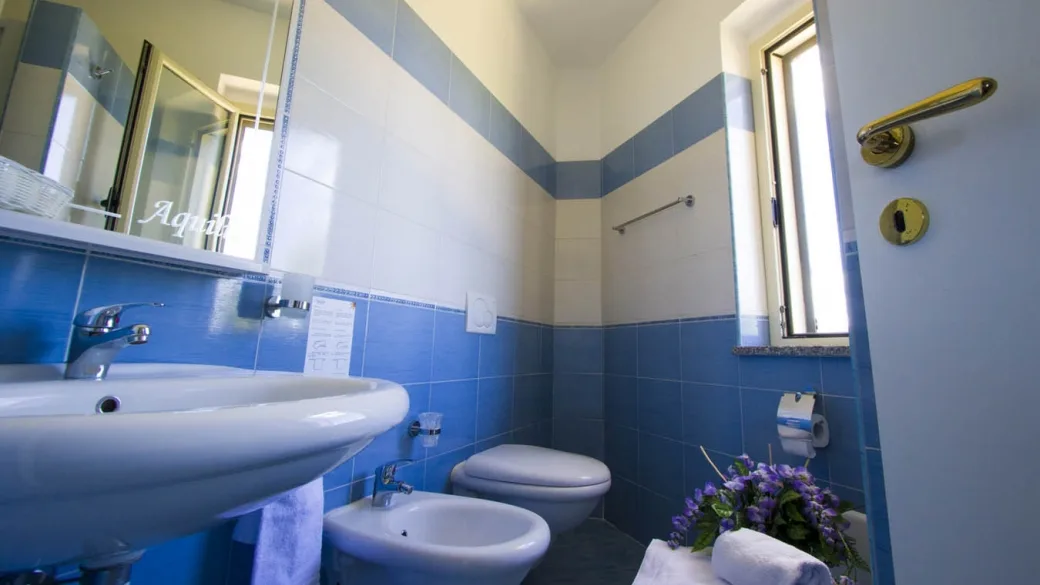 Bagno con lavabo, sanitari e piastrelle bianche e azzurre