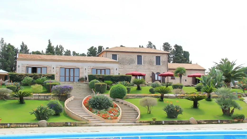Casale in pietra con giardino curato e scalinata fiorita