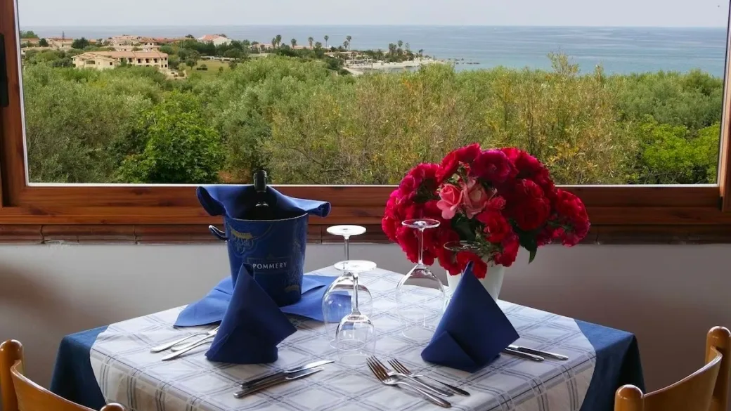 Tavolo apparecchiato con fiori e vista panoramica sul mare