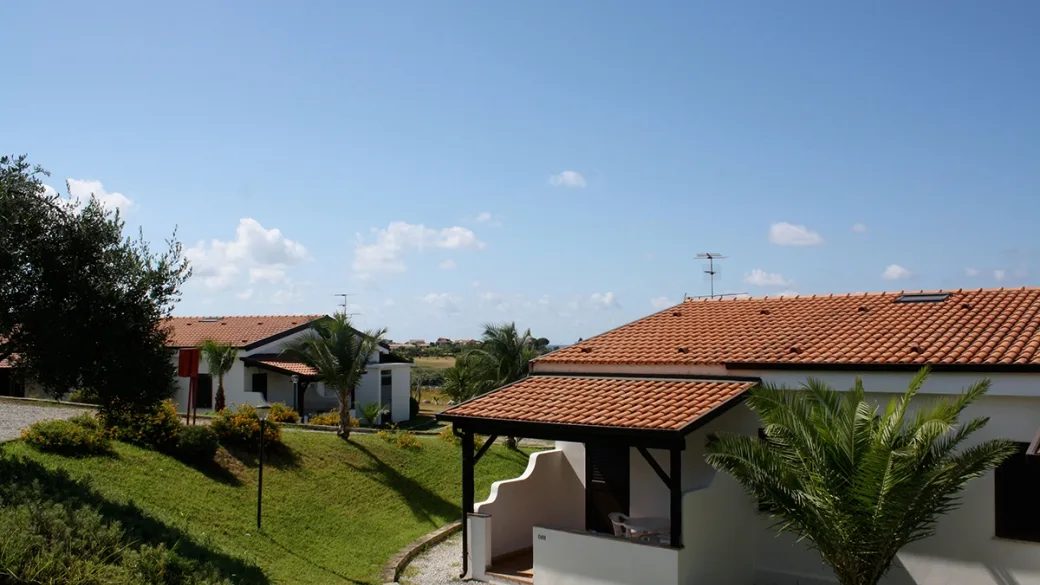 Bungalow con tetto in tegole circondati da giardino e palme