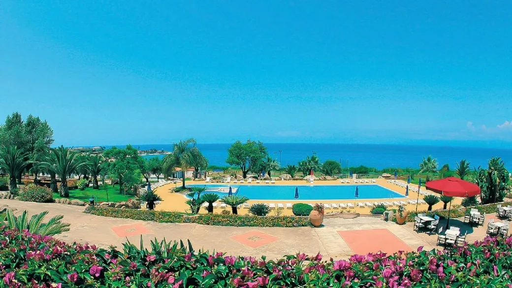 Vista panoramica della piscina e del mare dalla terrazza fiorita