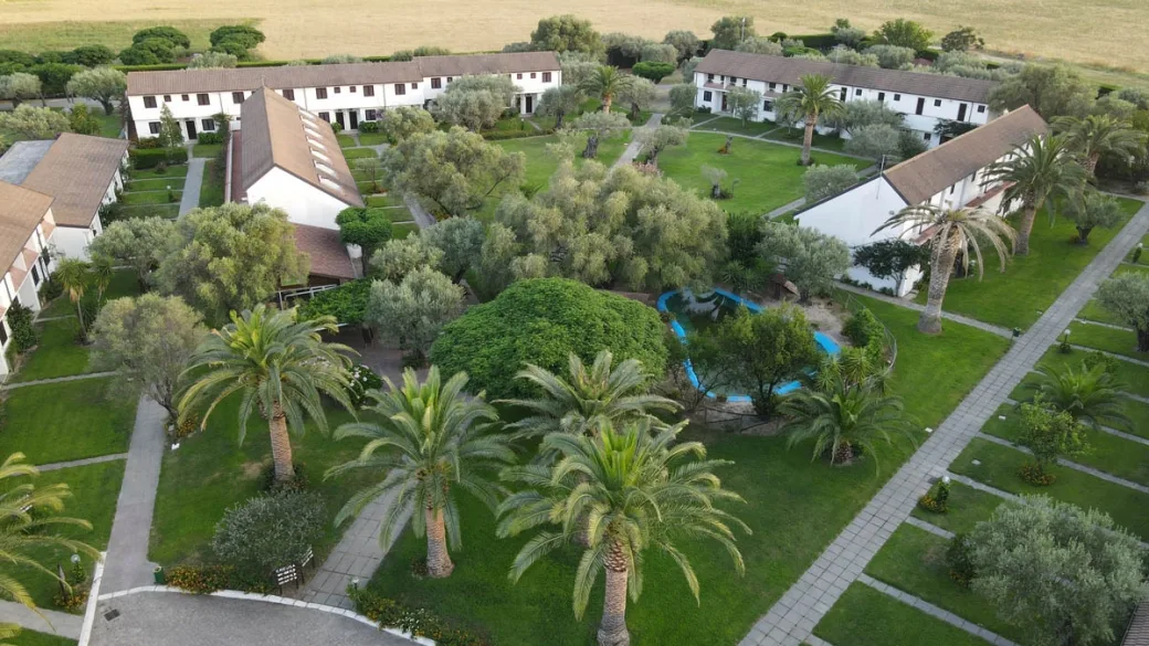 Veduta aerea del villaggio con alloggi bianchi immersi tra palme e giardini