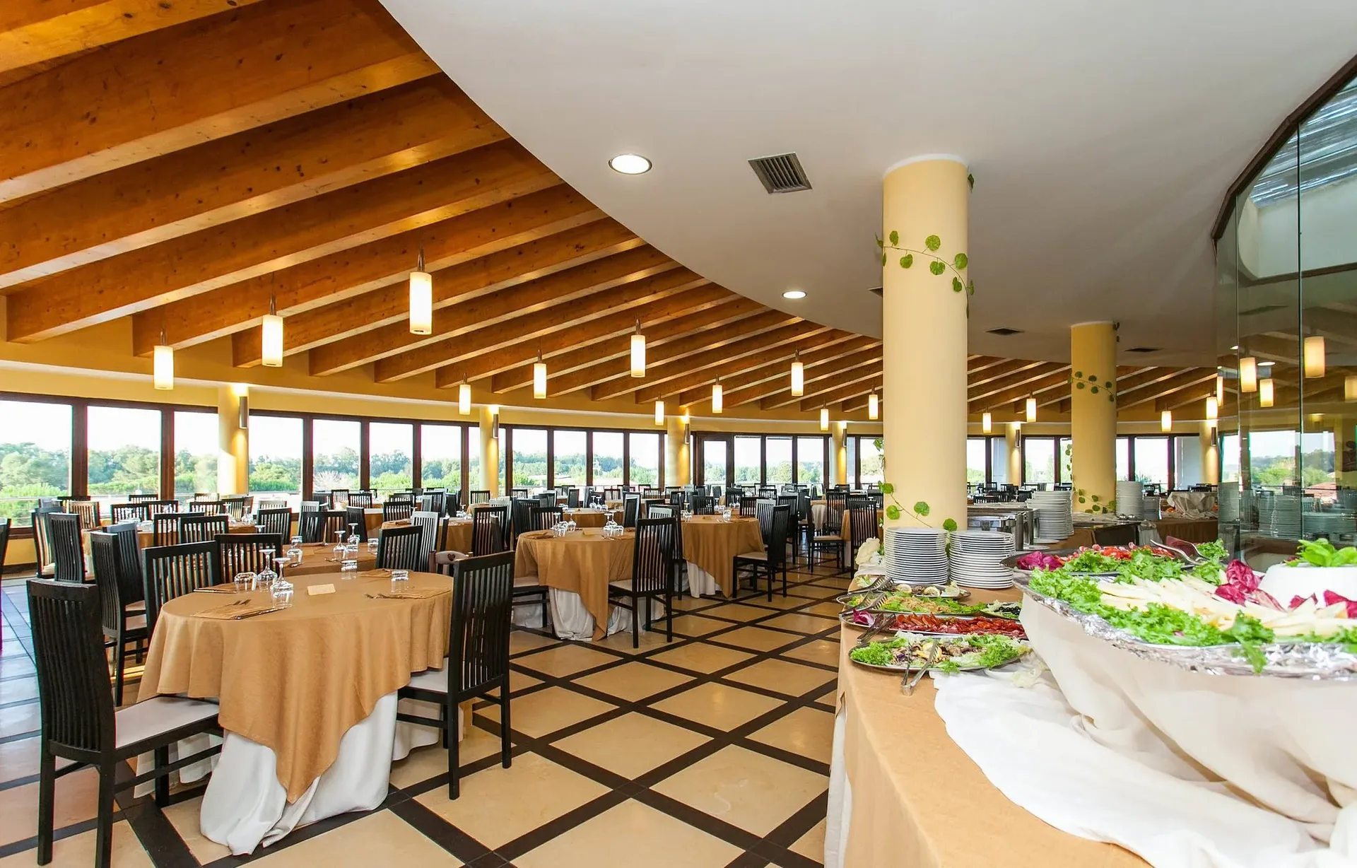 Ristorante con buffet di antipasti, tavoli apparecchiati e ampie vetrate panoramiche