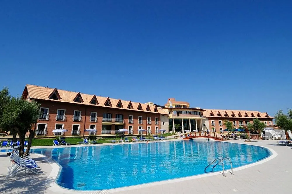 Facciata del resort in mattoni con grande piscina azzurra in primo piano