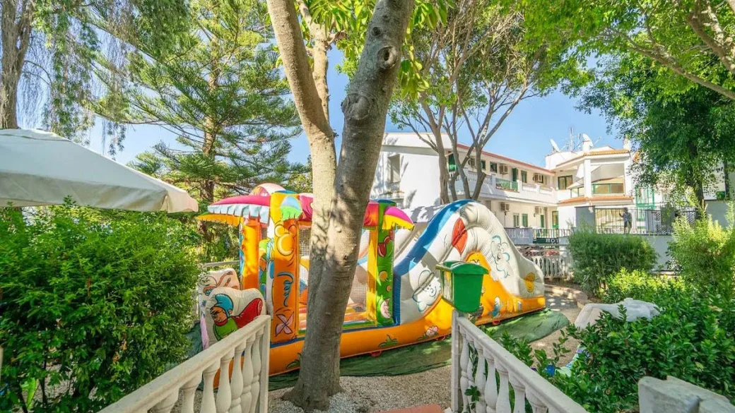 Area giochi per bambini con gonfiabile nel giardino dell'hotel