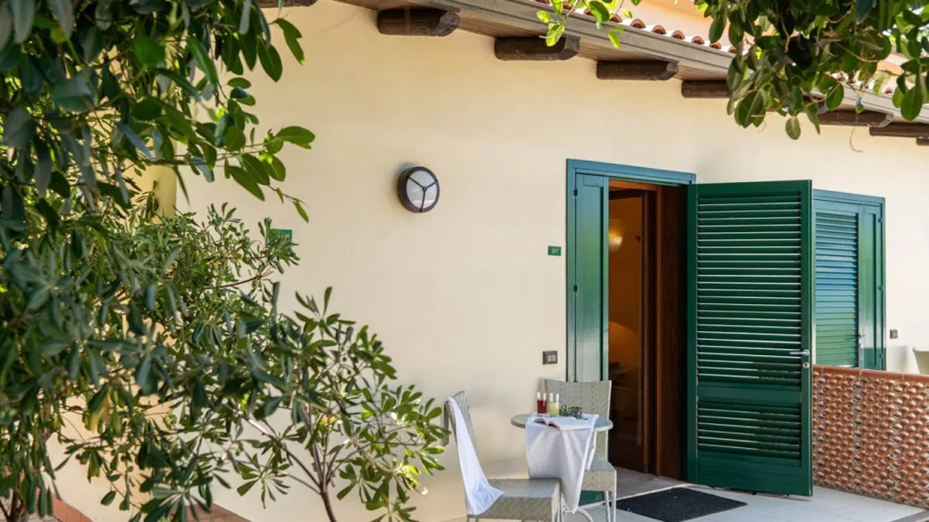 Terrazza privata di una camera con tavolino e persiane verdi