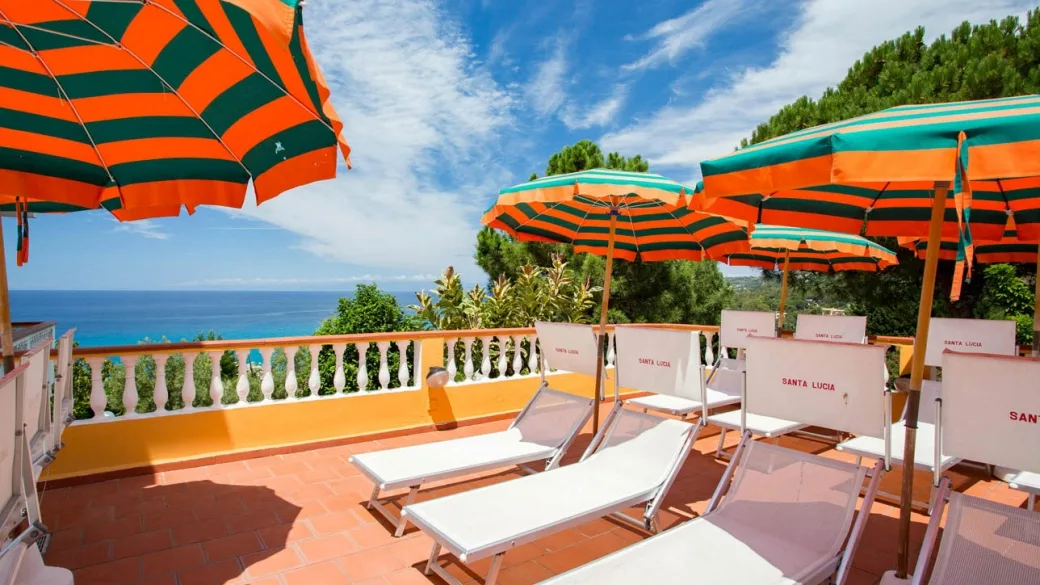 Terrazza con lettini e ombrelloni a righe con vista mare