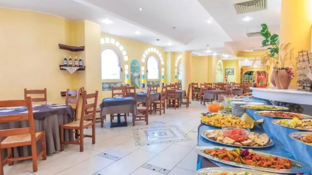 Sala ristorante con buffet ricco di pietanze e tavoli apparecchiati