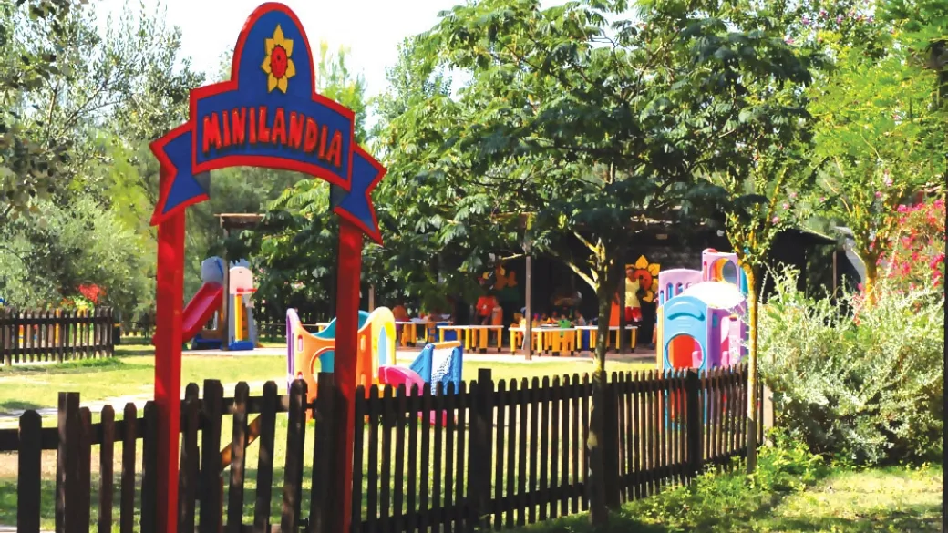 Area giochi Minilandia per bambini con scivoli colorati e recinzione in legno