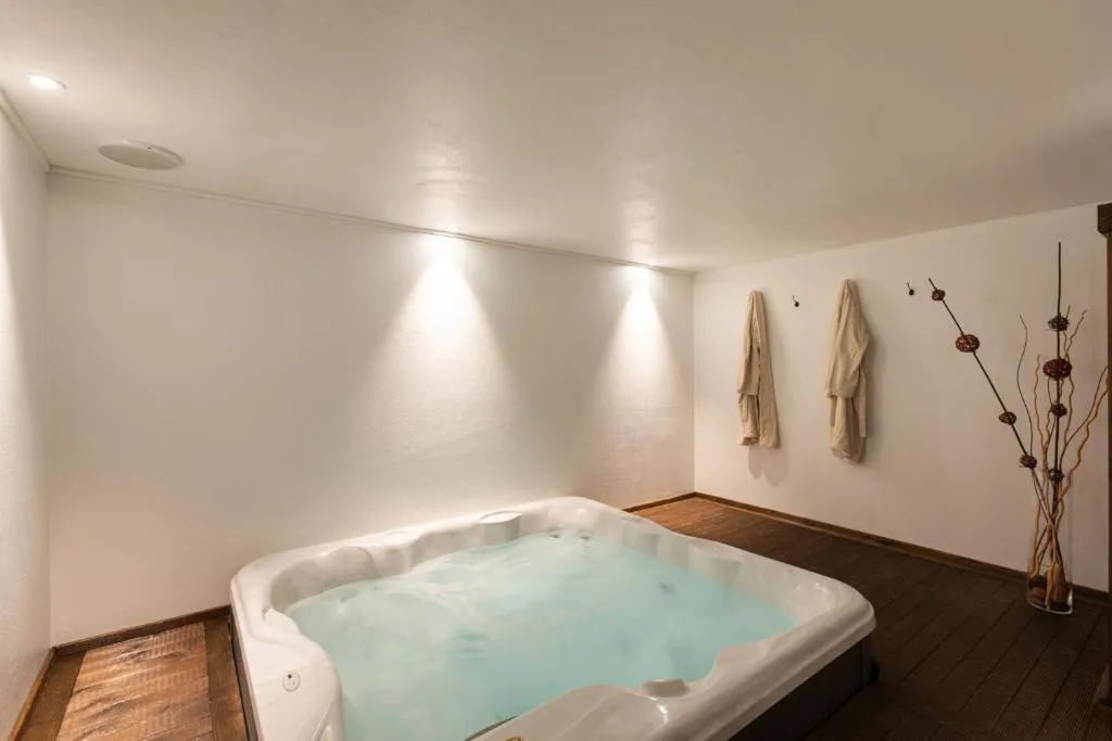 Vasca idromassaggio con accappatoi e decorazioni in ambiente rilassante