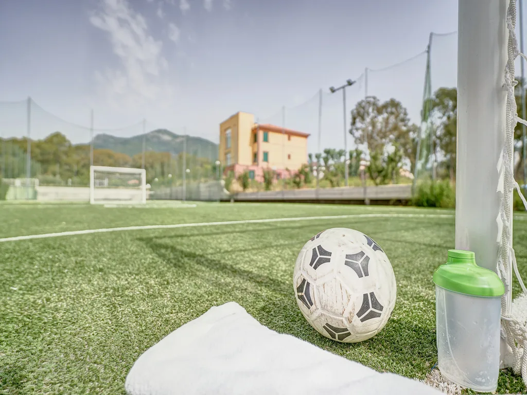 Campo da calcetto in erba sintetica con pallone e borraccia