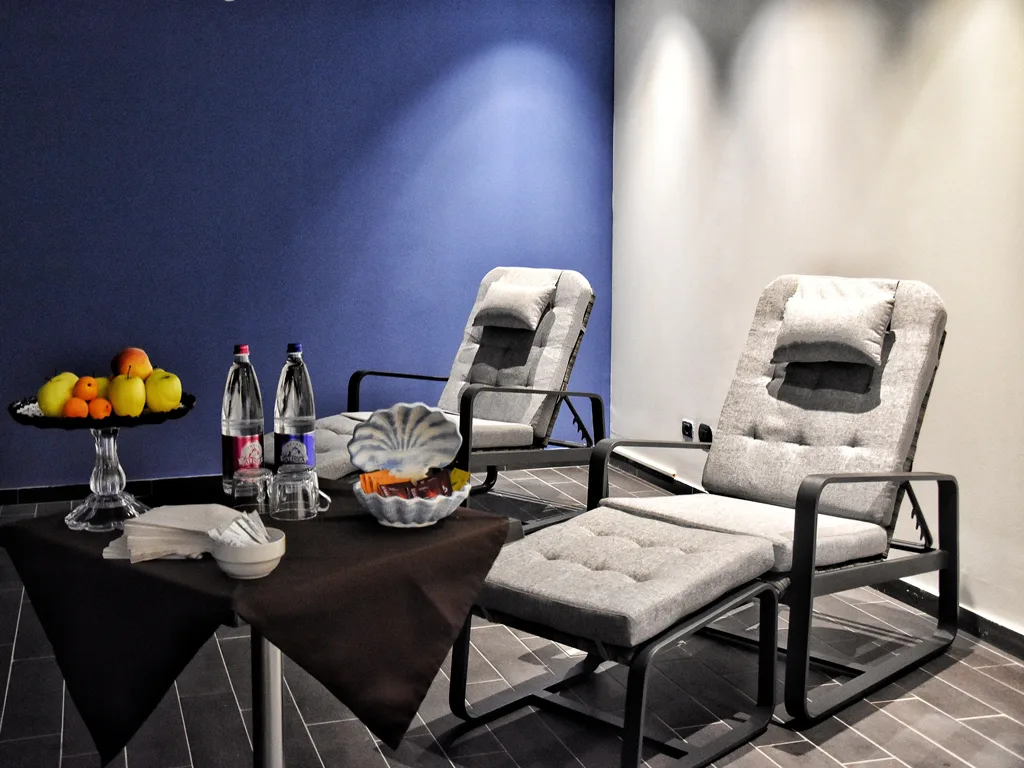 Area relax della spa con poltrone e tavolino con frutta e bevande