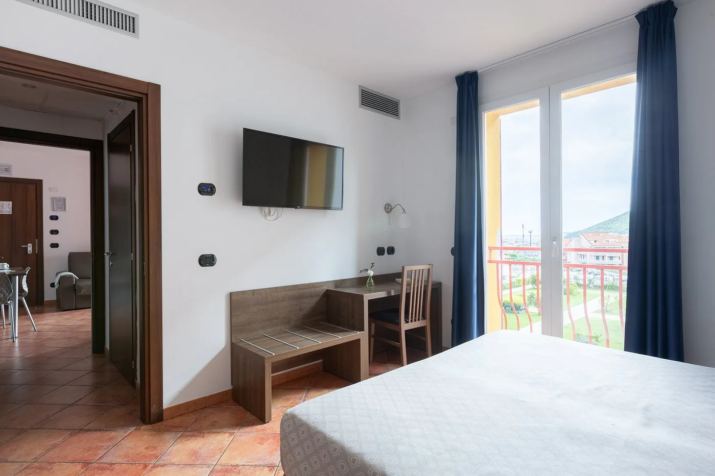 Camera con letto matrimoniale, TV, scrivania e uscita su balcone con vista