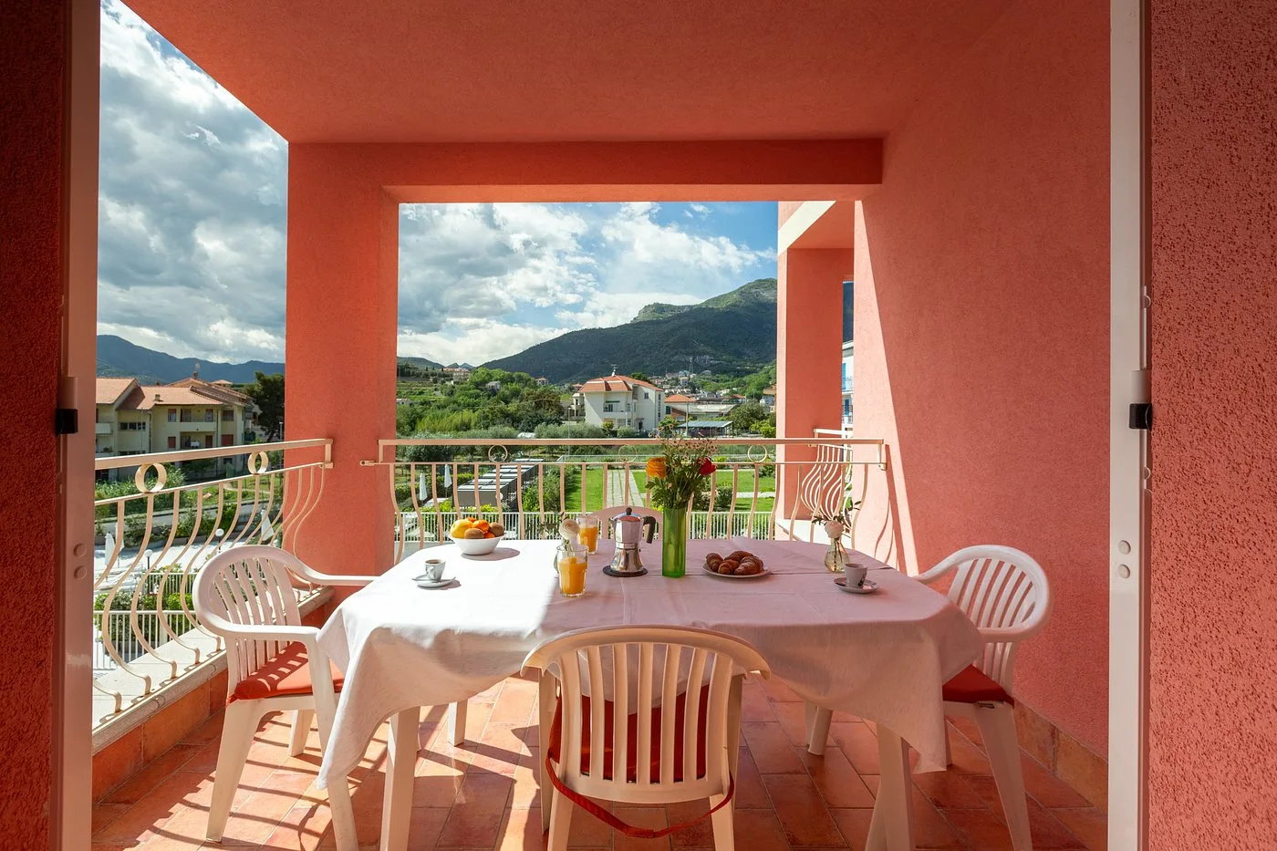 Terrazza con tavolo apparecchiato per la colazione e vista sulle colline dell'entroterra