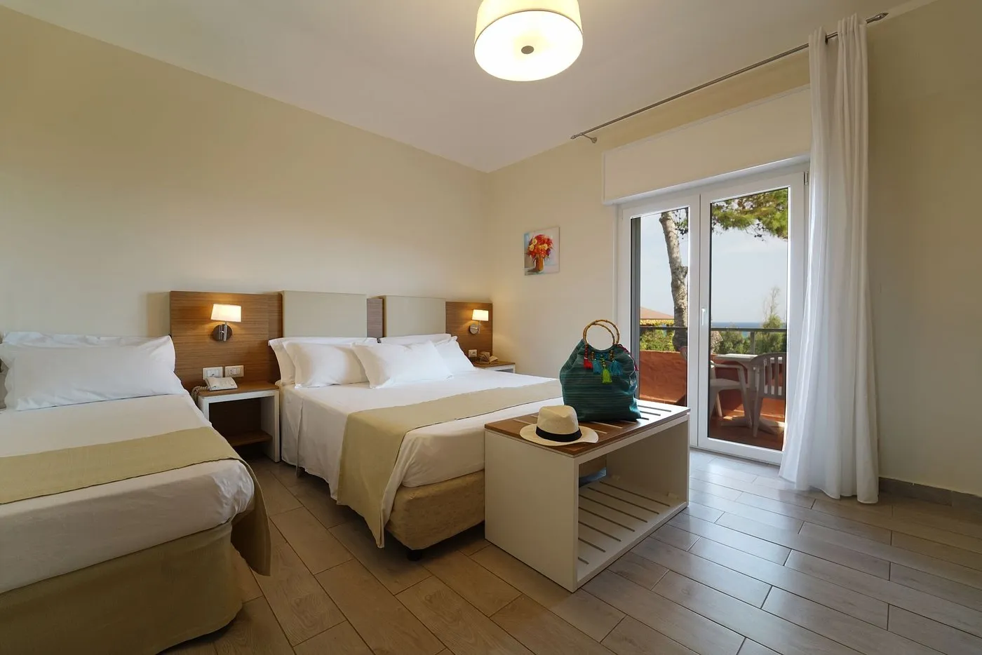 Camera tripla con letto matrimoniale e letto singolo, illuminazione soffusa e balcone con vista mare