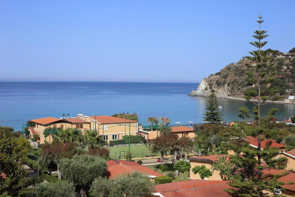 Vista panoramica del villaggio immerso nel verde con mare e promontorio