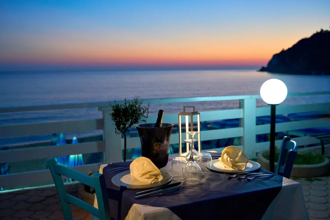 Tavolo romantico in terrazza con vista sul mare al tramonto