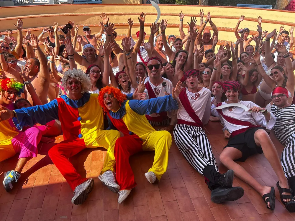 Gruppo di animatori e ospiti in costume durante una festa in piscina