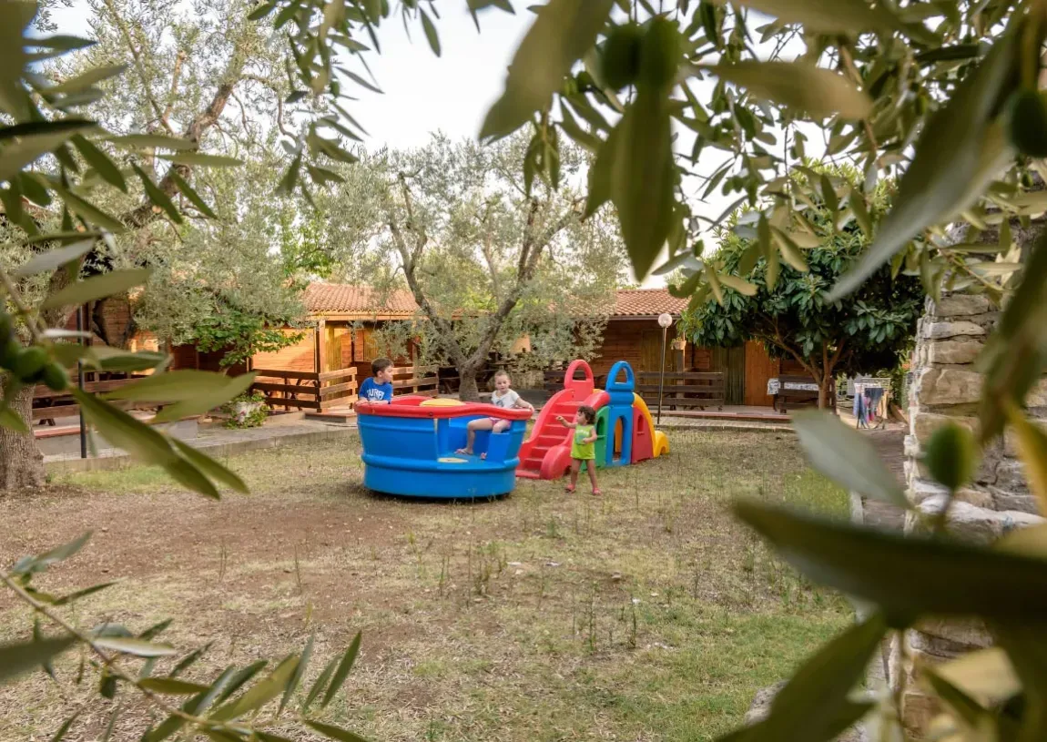 Area giochi per bambini nel giardino tra gli ulivi