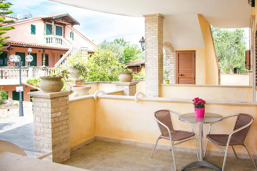 Terrazza privata con tavolino e sedie affacciata sul giardino della struttura