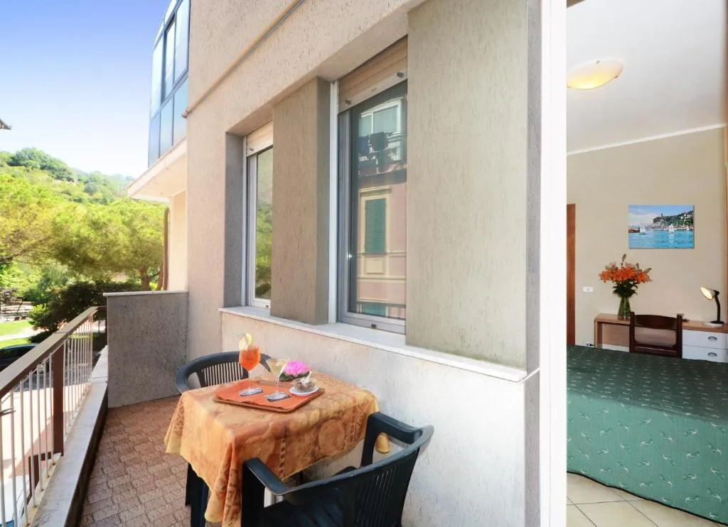 Balcone con tavolino e sedie affacciato sul verde, collegato alla camera