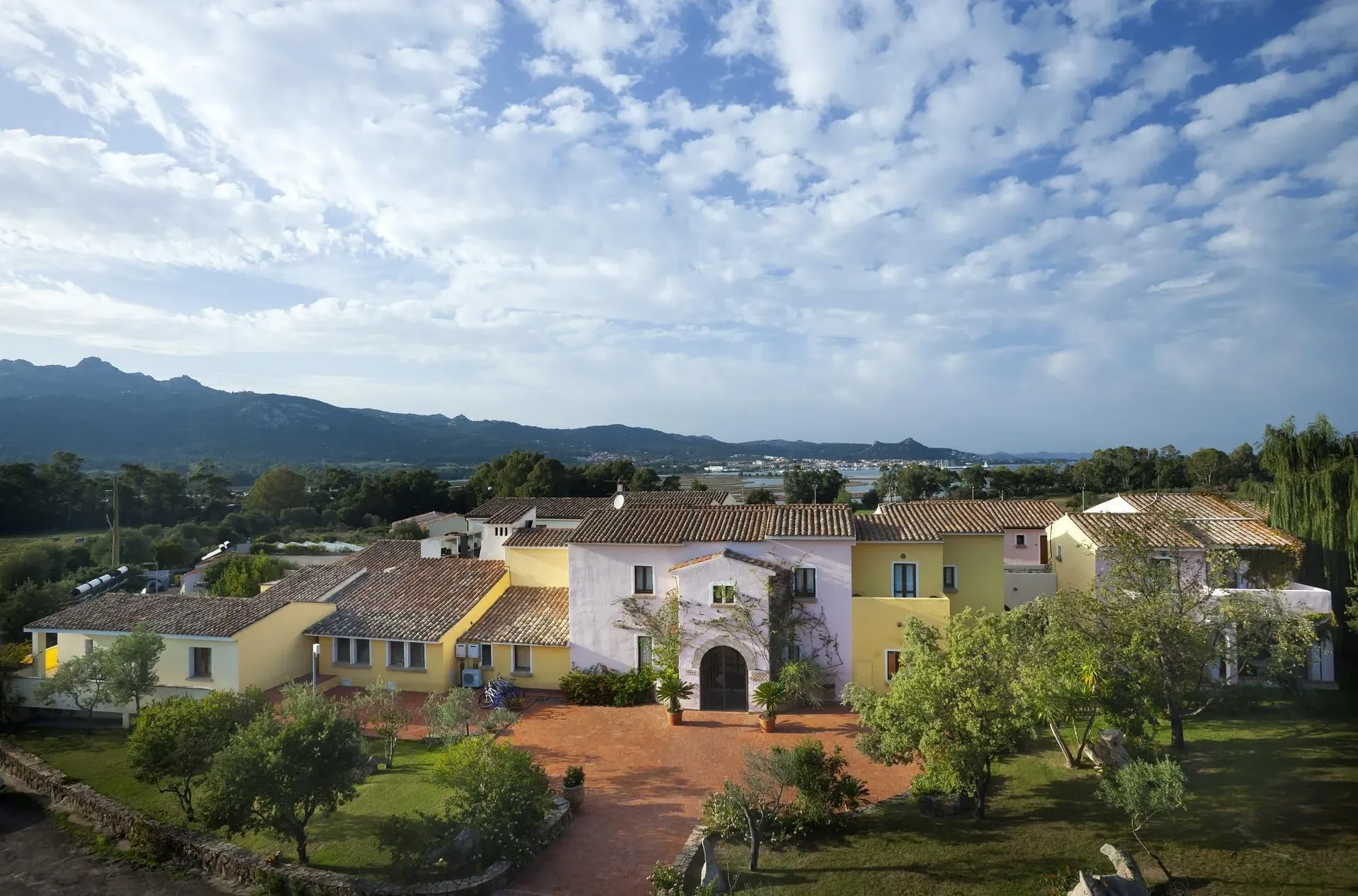 Vista aerea del complesso alberghiero con edifici colorati e montagne sullo sfondo