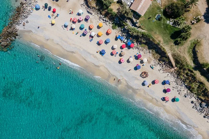 Vista aerea della spiaggia con ombrelloni e acqua turchese