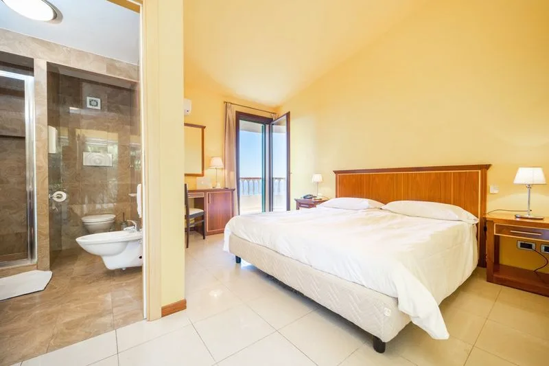 Camera matrimoniale luminosa con bagno privato e balcone vista mare