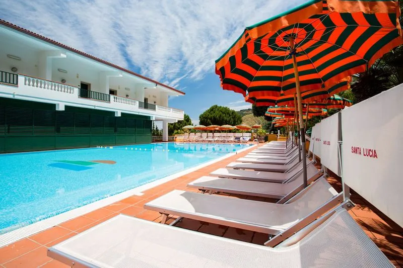 Bordo piscina con lettini e ombrelloni a righe arancioni e verdi