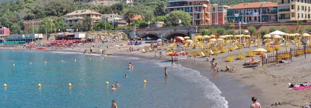 Spiaggia di sabbia con ombrelloni colorati e bagnanti in mare