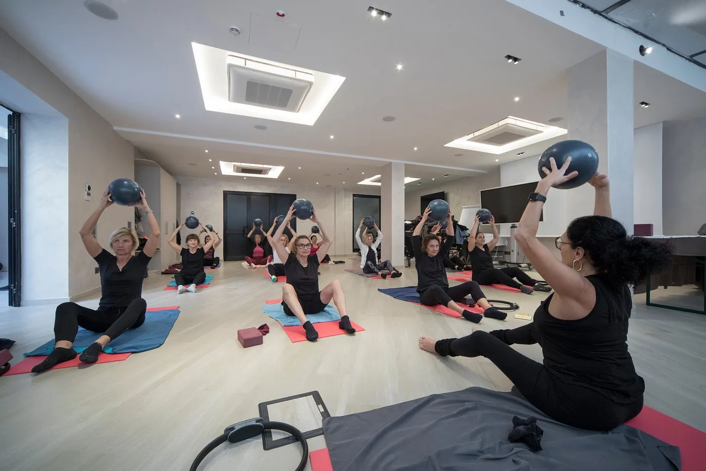 Lezione di pilates con palloni in una sala fitness luminosa dell'hotel