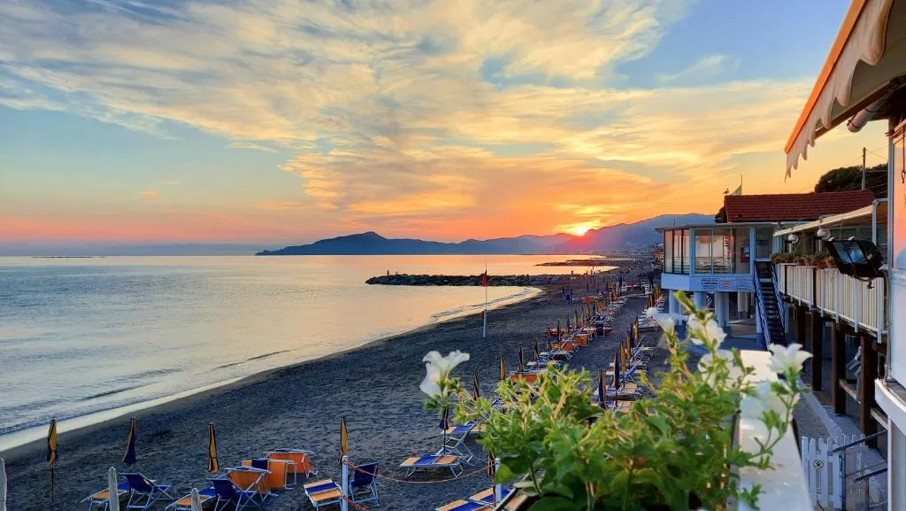 Spiaggia con lettini e ombrelloni al tramonto sul mare