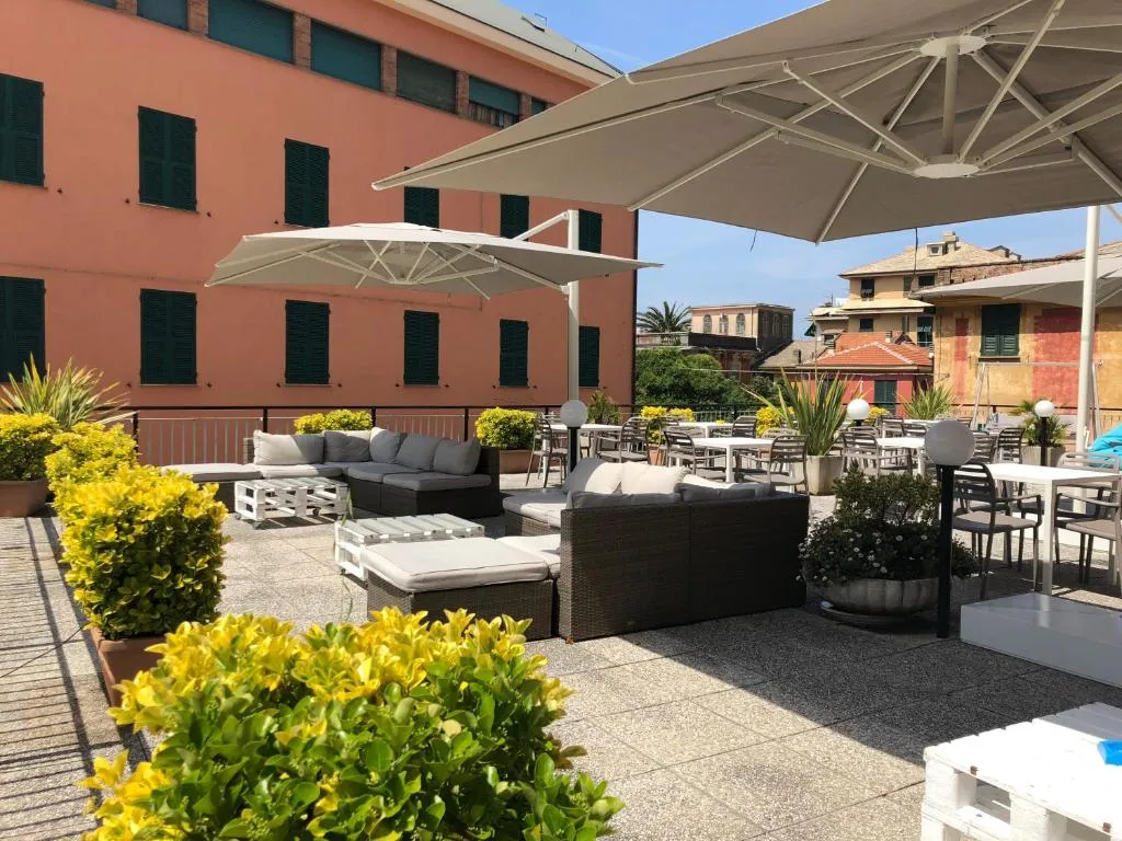 Terrazza soleggiata con divani, ombrelloni bianchi e piante fiorite