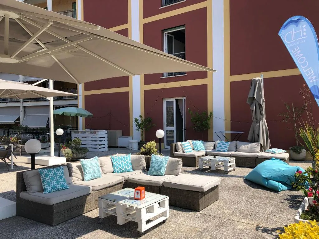 Area lounge esterna con divani, cuscini turchesi e bandiera dell'hotel