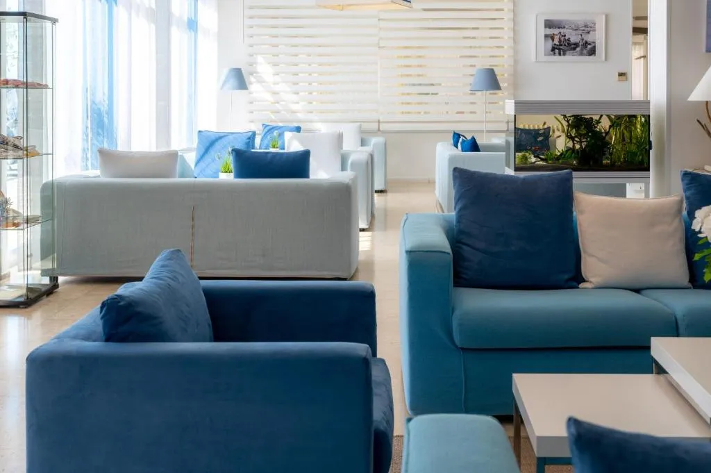 Salotto elegante con divani azzurri e bianchi e acquario