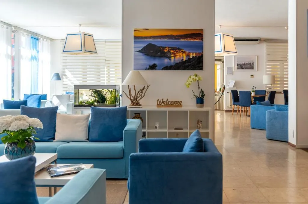 Hall luminosa con divani azzurri, acquario e quadro panoramico