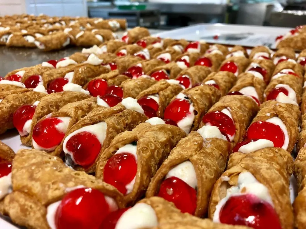 Cannoli siciliani ripieni di crema con ciliegie candite