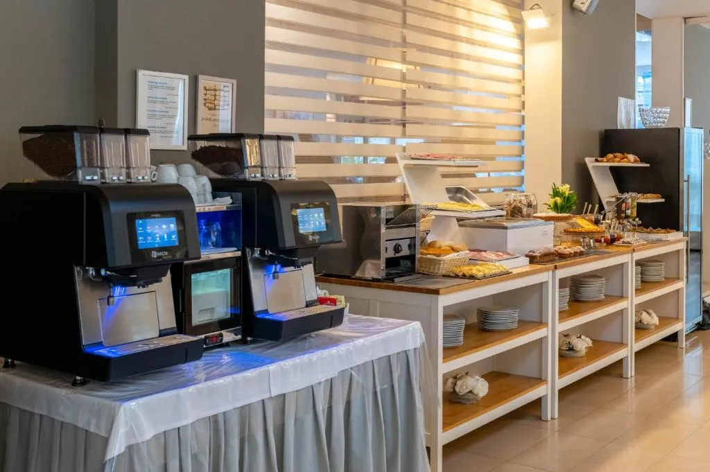 Angolo colazione con macchine del caffè e buffet di dolci