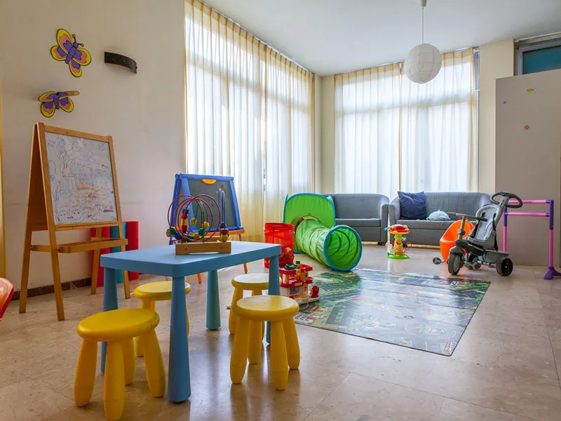 Sala giochi per bambini con tavolino, lavagna e giocattoli colorati