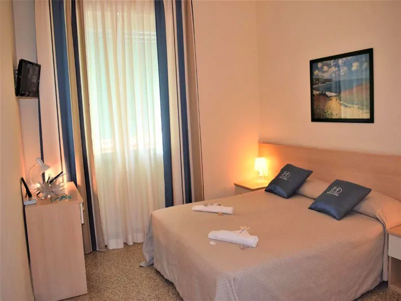 Camera luminosa con letto, TV a parete e quadro paesaggistico