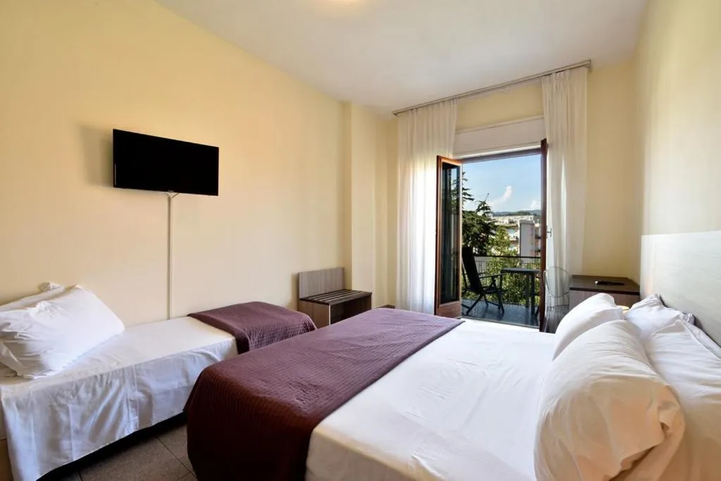 Camera con letto matrimoniale e singolo, TV e balcone con vista