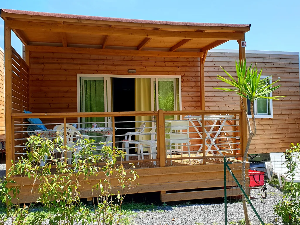 Casa mobile in legno con ampia veranda arredata e tavolo da pranzo
